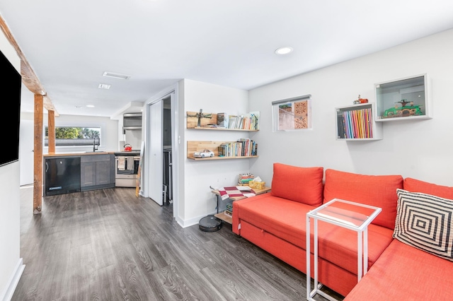 living area with recessed lighting, dark wood-style floors, visible vents, and baseboards