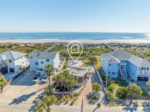 birds eye view of property with a water view and a beach view