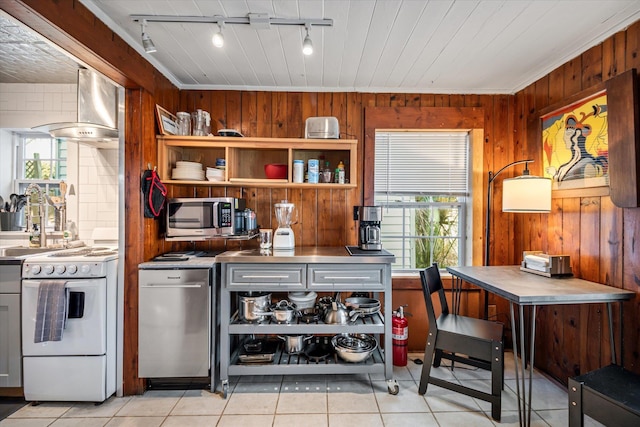 interior space with stainless steel counters, rail lighting, wall chimney range hood, white range oven, and wood walls