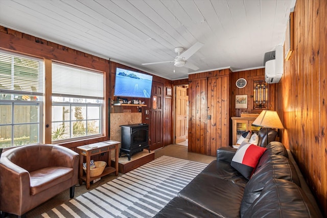 carpeted living room featuring a wood stove, wood walls, ceiling fan, wooden ceiling, and a wall mounted air conditioner