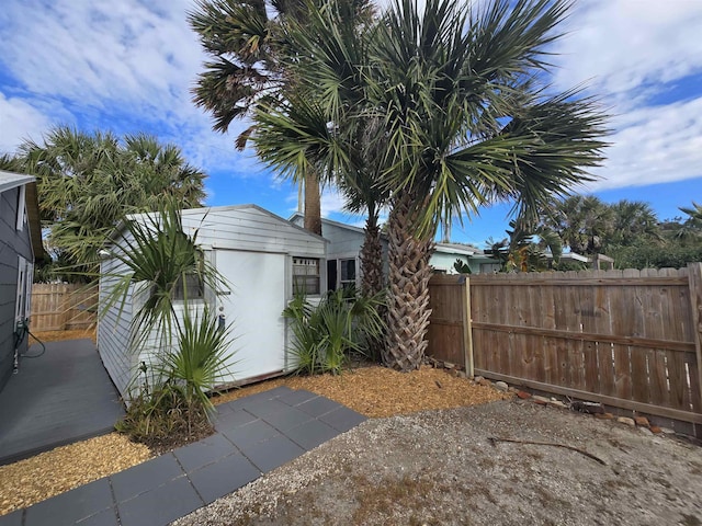 exterior space featuring an outbuilding, fence private yard, and stucco siding