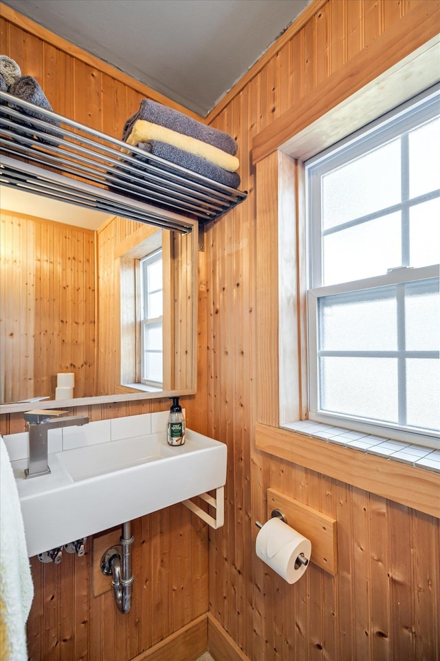 bathroom with a wealth of natural light and wooden walls