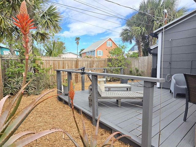 wooden terrace with a fenced backyard