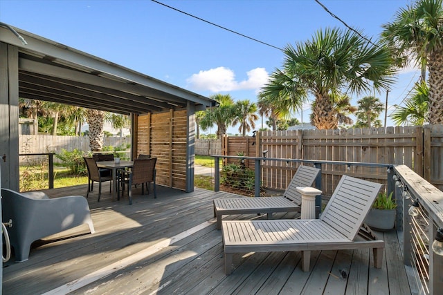 wooden deck with outdoor dining space and a fenced backyard