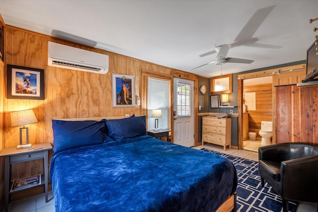 bedroom with ensuite bath, a wall mounted AC, wooden walls, and ceiling fan