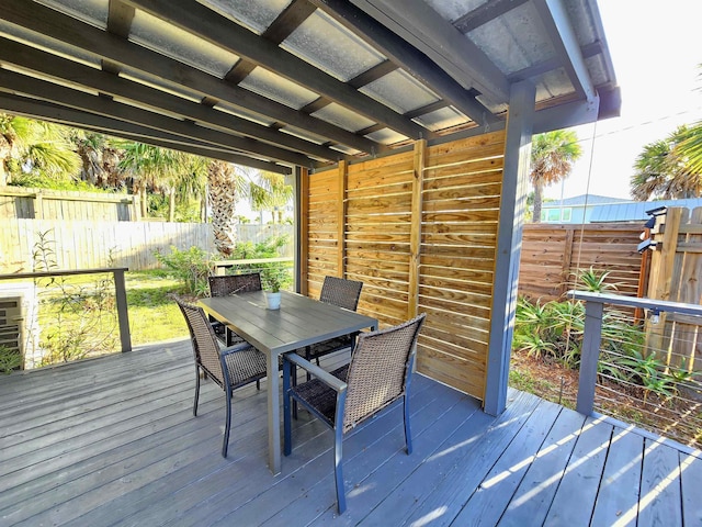 deck with outdoor dining area and a fenced backyard