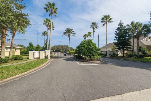 view of road featuring curbs, a gated entry, and a gate