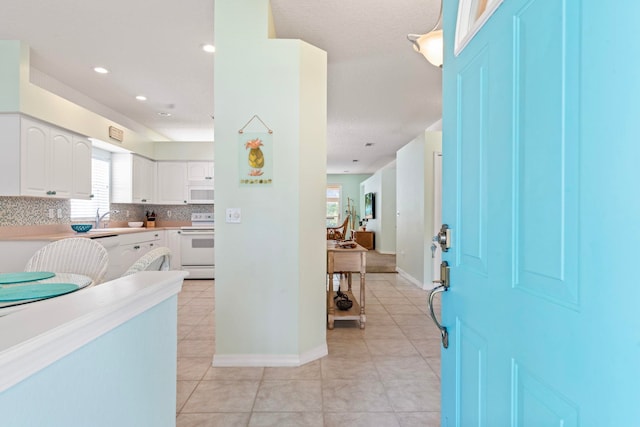 entrance foyer featuring recessed lighting, light tile patterned flooring, and baseboards