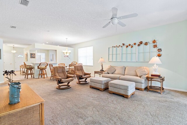 living area featuring carpet flooring, visible vents, and a textured ceiling