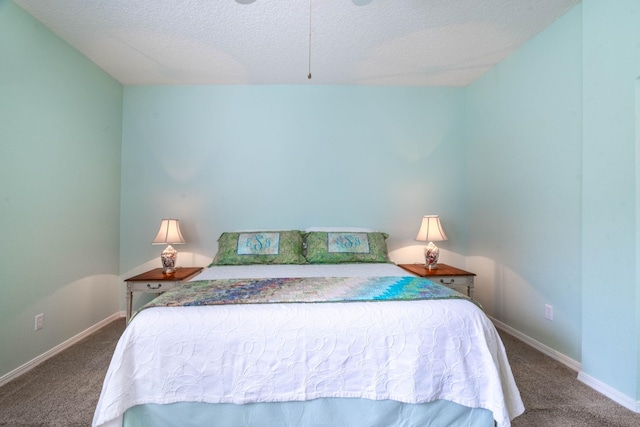 bedroom featuring carpet, baseboards, and a textured ceiling