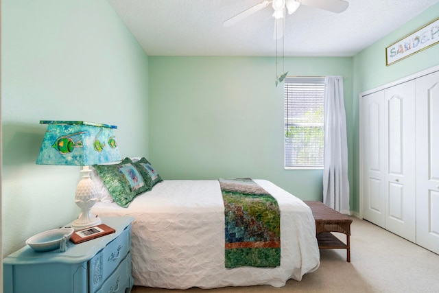 carpeted bedroom featuring a ceiling fan, a closet, and a textured ceiling