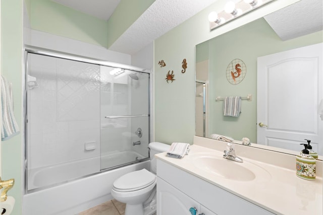 bathroom with a textured ceiling, toilet, vanity, combined bath / shower with glass door, and tile patterned floors