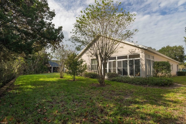 back of property with a yard and stucco siding