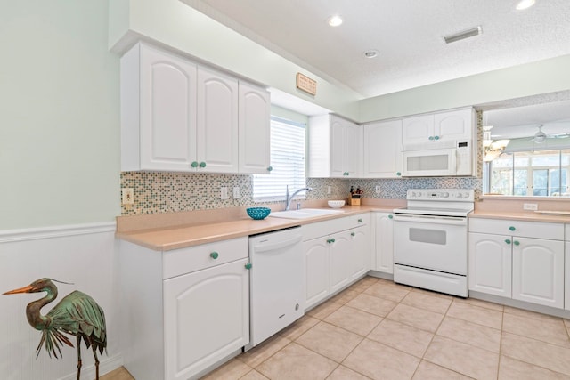 kitchen featuring white appliances, light tile patterned floors, visible vents, light countertops, and a sink