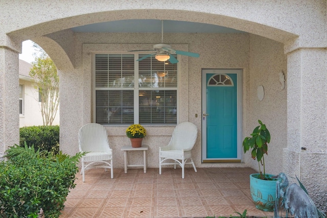 property entrance featuring a patio area, a ceiling fan, and stucco siding