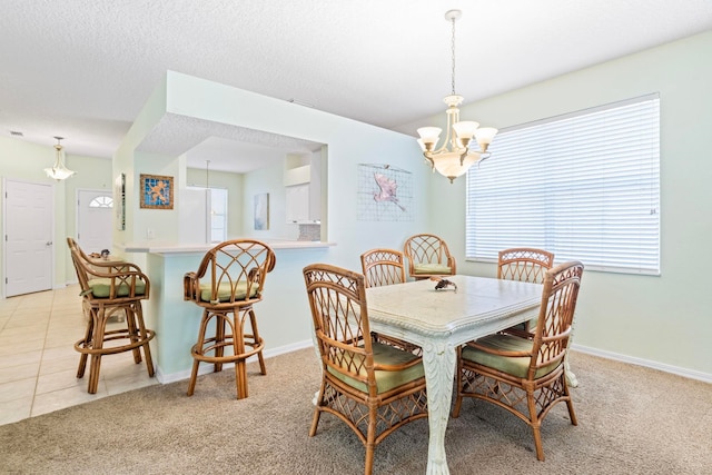 dining room featuring a chandelier, light carpet, a textured ceiling, and baseboards