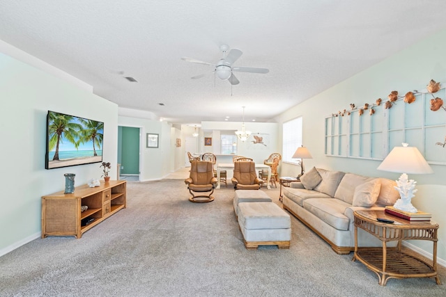 living room with visible vents, baseboards, carpet, a textured ceiling, and ceiling fan with notable chandelier