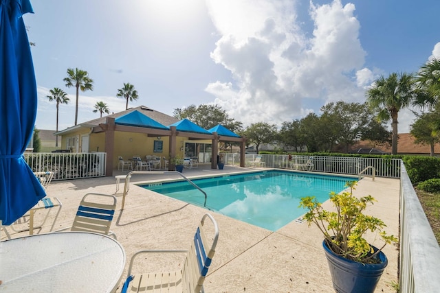 pool featuring a patio, outdoor dining area, and fence