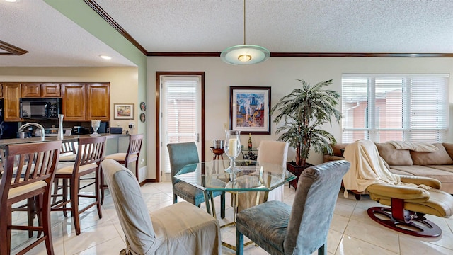 dining area featuring a textured ceiling, light tile patterned floors, ornamental molding, and plenty of natural light