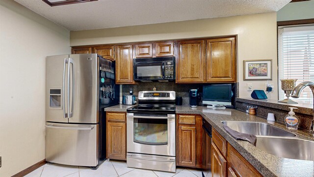 kitchen with a sink, brown cabinetry, and stainless steel appliances