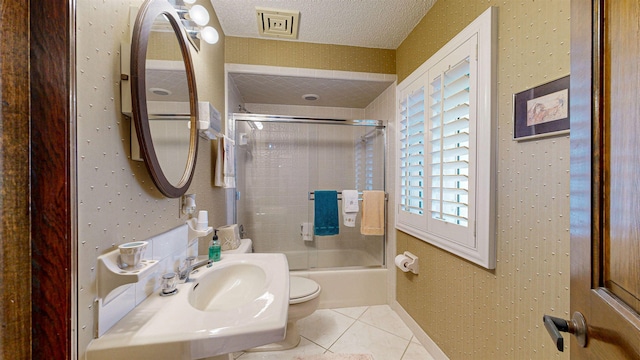full bathroom featuring a textured ceiling, visible vents, toilet, enclosed tub / shower combo, and tile patterned floors