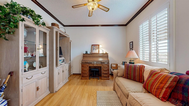 living room featuring crown molding, light wood-style flooring, a ceiling fan, and a textured ceiling