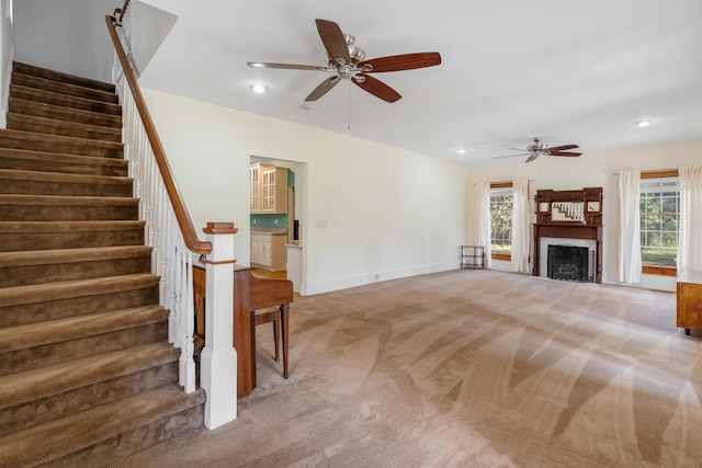 unfurnished living room with carpet floors and ceiling fan