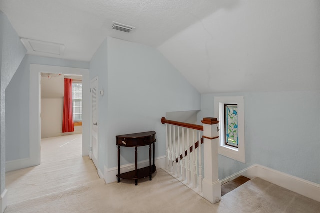 bonus room featuring light carpet, a textured ceiling, and vaulted ceiling