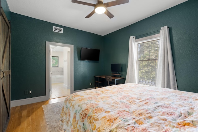 bedroom featuring ceiling fan, connected bathroom, and light hardwood / wood-style flooring