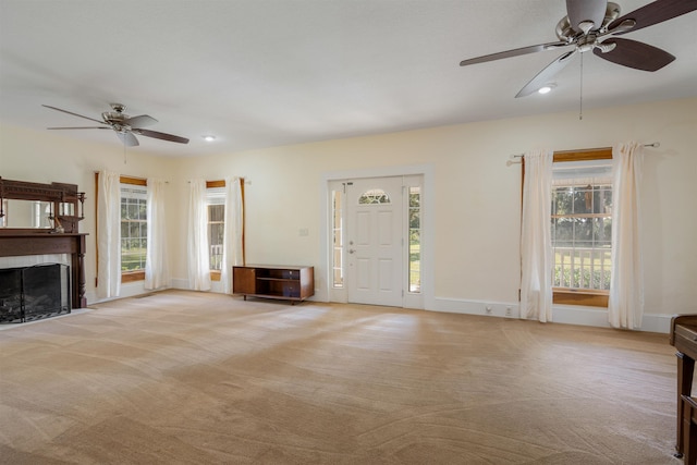 unfurnished living room featuring light carpet and ceiling fan