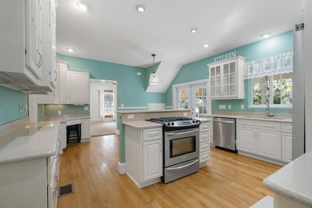 kitchen with white cabinets, appliances with stainless steel finishes, pendant lighting, and sink