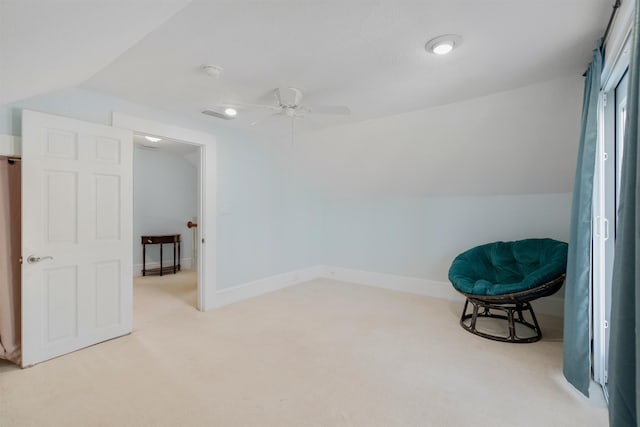 sitting room with ceiling fan, light colored carpet, and vaulted ceiling