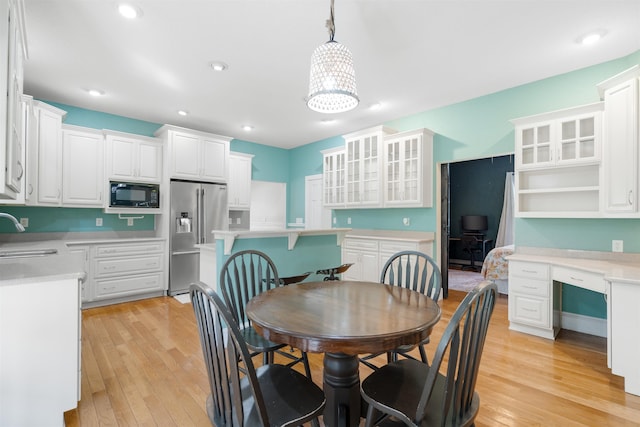 dining space featuring sink and light hardwood / wood-style flooring