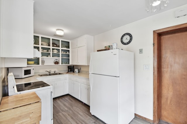 1300 Francis St, Saint Augustine, FL 32084 - kitchen featuring a sink, white appliances, wood finished floors, white cabinetry, and light countertops
