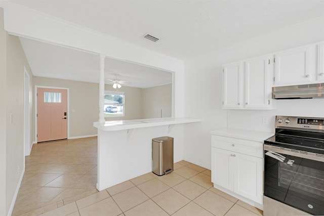 kitchen with light tile patterned floors, kitchen peninsula, electric stove, ceiling fan, and white cabinets