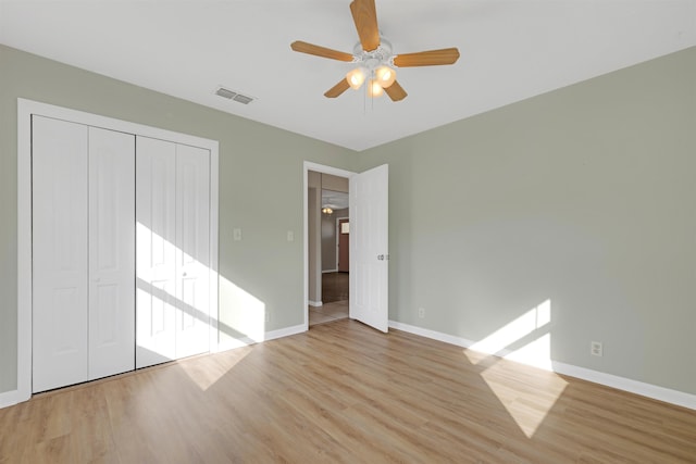 unfurnished bedroom with ceiling fan, light hardwood / wood-style floors, and a closet