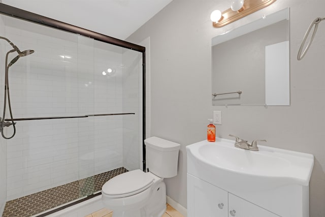 bathroom featuring vanity, walk in shower, tile patterned floors, and toilet