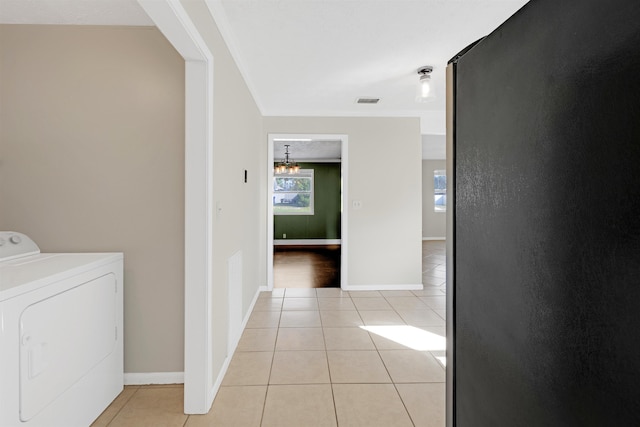 laundry area featuring washer / dryer and light tile patterned floors