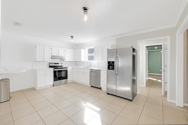 kitchen with sink, white cabinetry, crown molding, light tile patterned floors, and appliances with stainless steel finishes