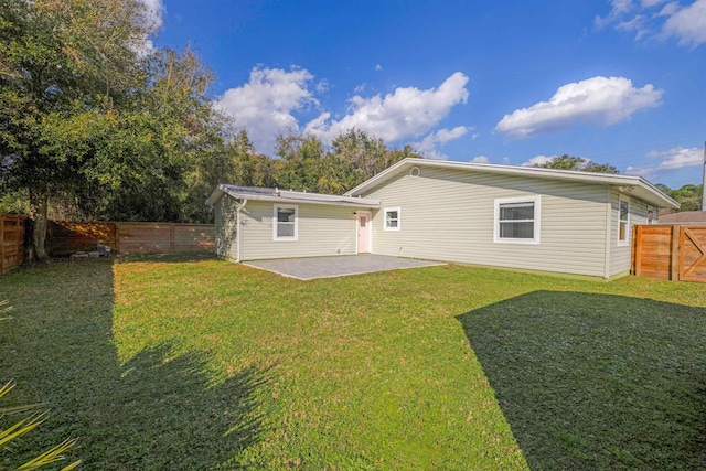 back of property featuring a yard and a patio