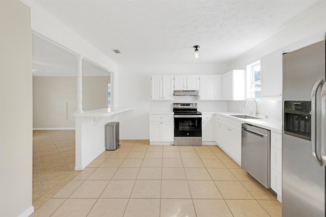 kitchen with light tile patterned flooring, sink, white cabinetry, kitchen peninsula, and stainless steel appliances