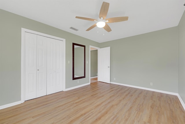 unfurnished bedroom with ceiling fan, light hardwood / wood-style floors, and a closet