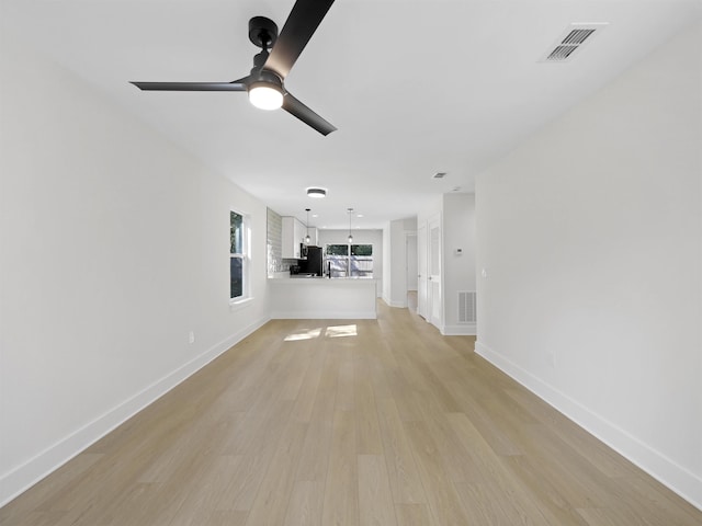 unfurnished living room featuring ceiling fan and light hardwood / wood-style floors