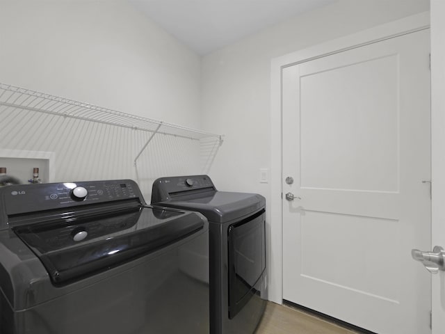 washroom featuring light hardwood / wood-style flooring and washer and clothes dryer