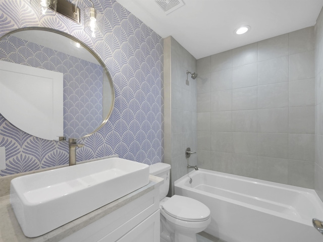 full bathroom with vanity, toilet, and tiled shower / bath combo