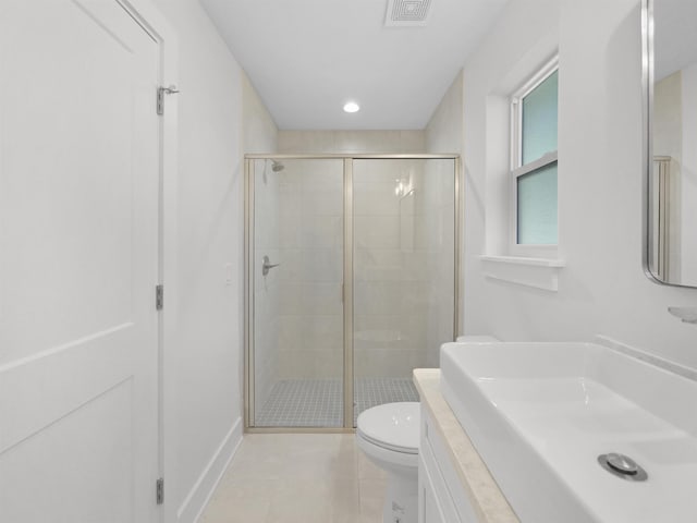 bathroom with sink, tile patterned floors, a shower with door, and toilet