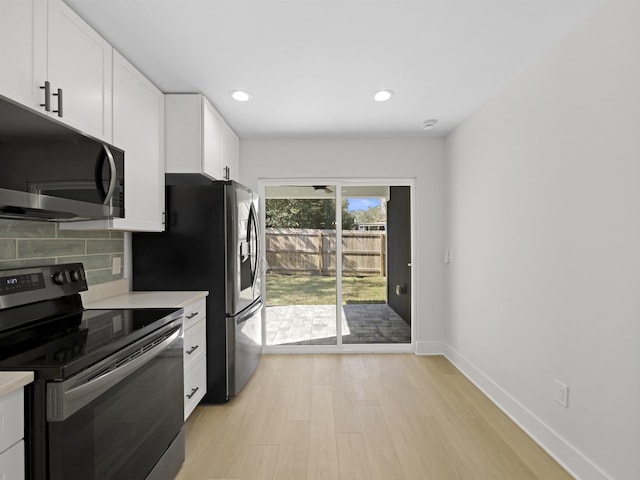 kitchen featuring backsplash, appliances with stainless steel finishes, light wood-type flooring, and white cabinets