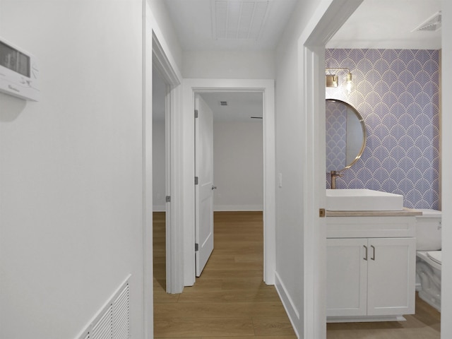 hallway featuring sink and light wood-type flooring