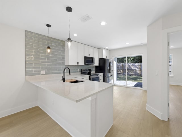 kitchen featuring sink, white cabinets, hanging light fixtures, kitchen peninsula, and stainless steel appliances