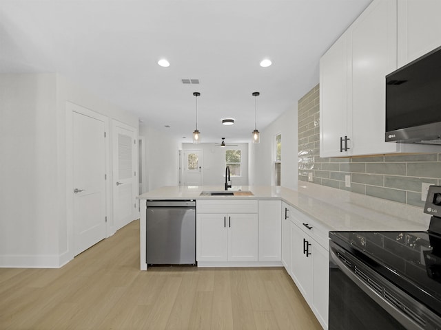 kitchen featuring black electric range oven, sink, stainless steel dishwasher, kitchen peninsula, and pendant lighting